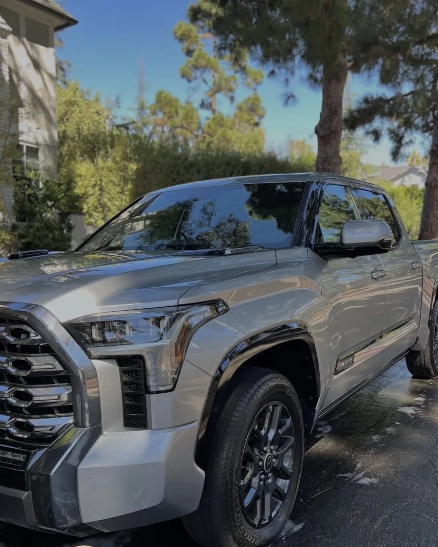 The same Toyota Tundra after detailing, silver paint and black wheels gleaming in the sun